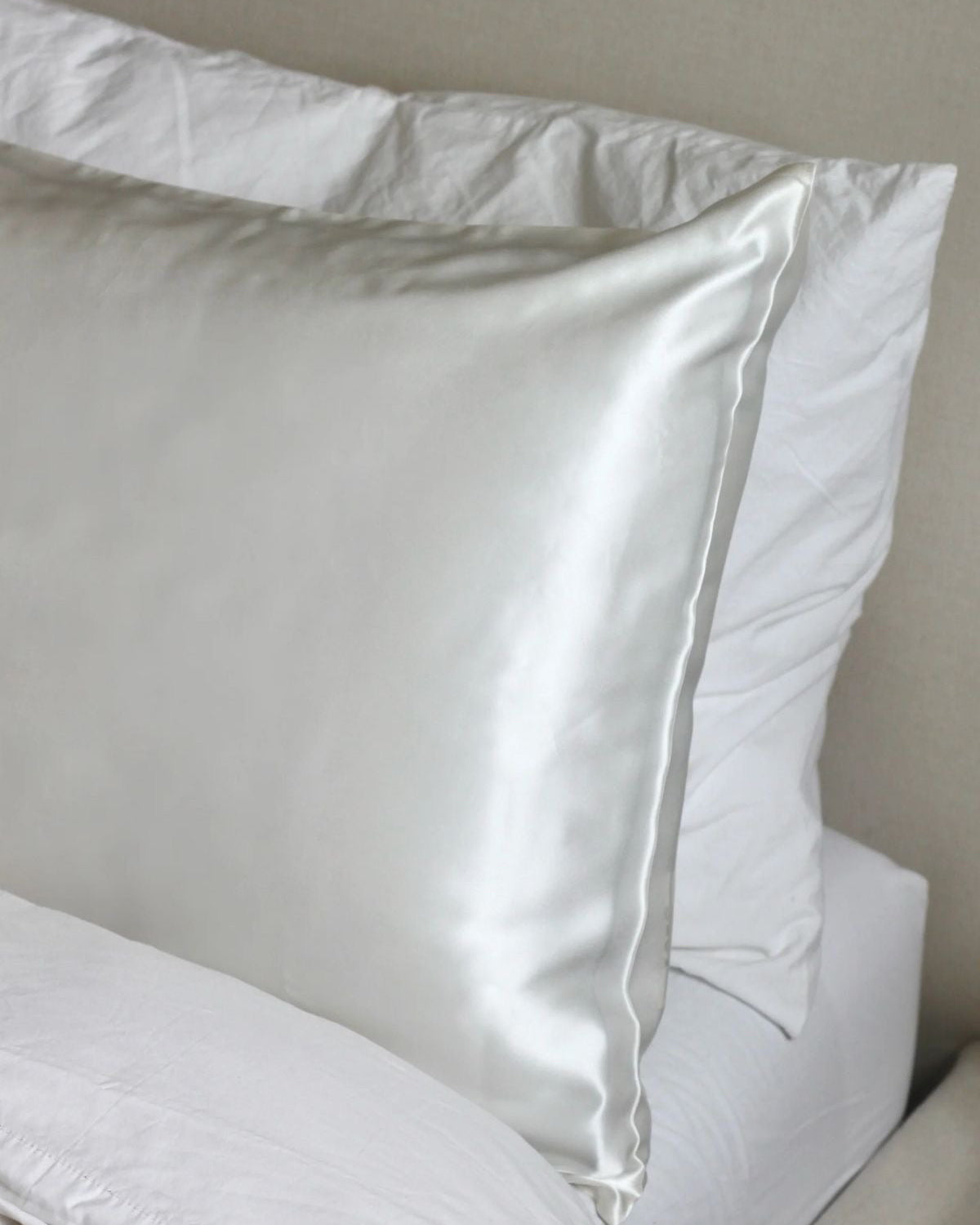 Close-up of white SILK pillowcases on a neutral background